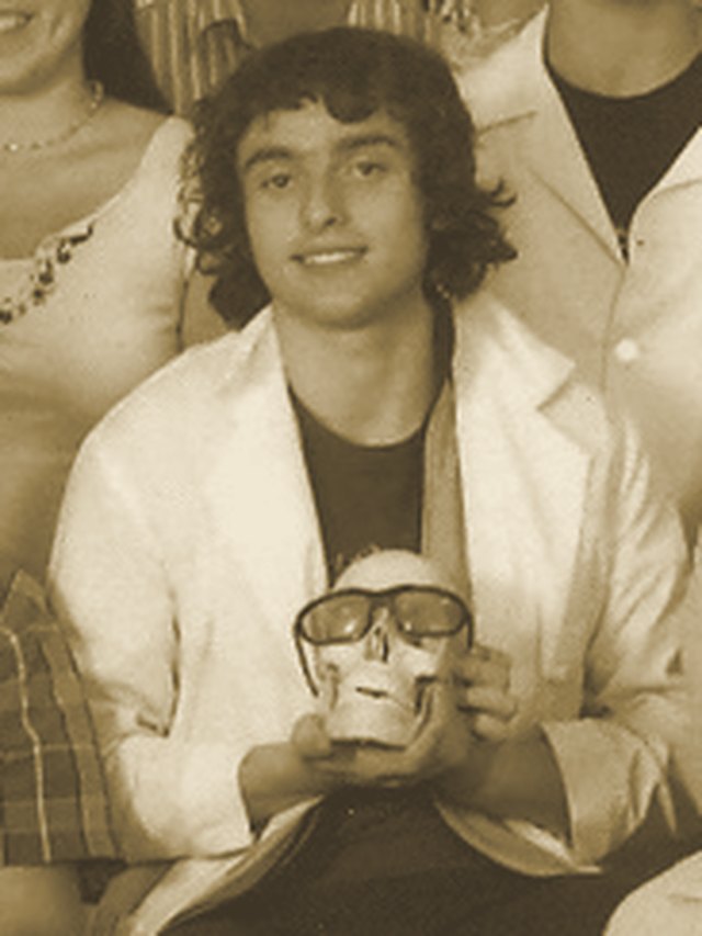 Rory at seventeen in a white coat, holding a skull in a high-school anatomy class